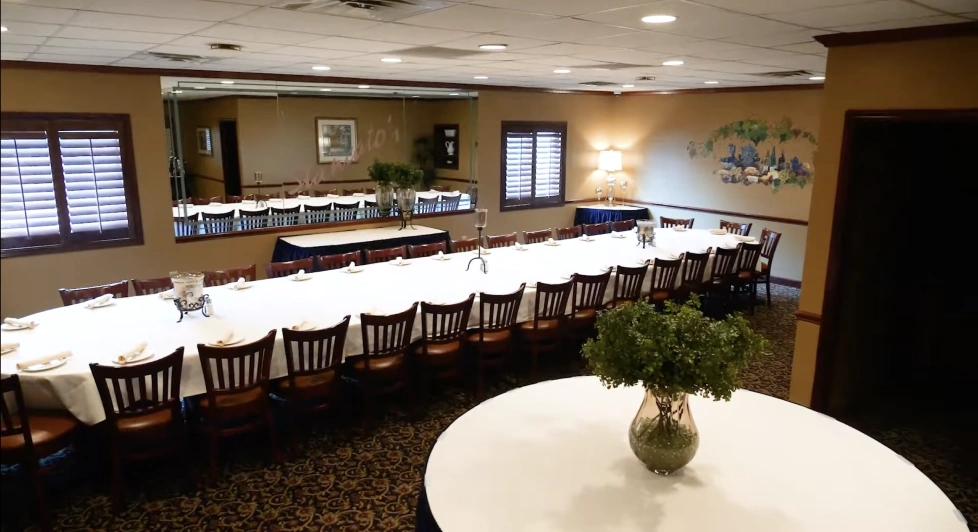 Festivali private dining room. Seats 30 to 40 guests. There is one long table with white tablecloth and wooden chairs.