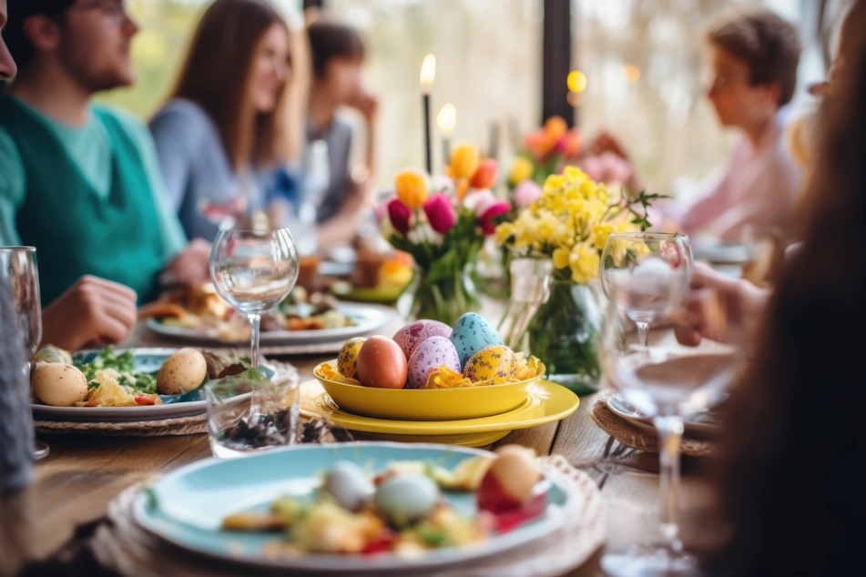 Easter dinner table setting with pastel colored eggs in the center