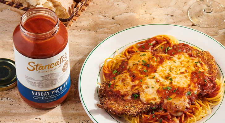 A plate of chicken parmigiana with a jar of Stancato's Sunday Premier Sauce next to it.